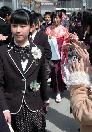 大槌小学校の卒業式を終えて在校生に拍手で送られる児童たち＝2014年3月19日、大槌町の大槌小