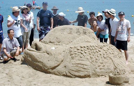 「砂の祭典」で制作された「南部鼻曲がり鮭」です＝2014年7月26日、大槌町の吉里吉里海岸海水浴場