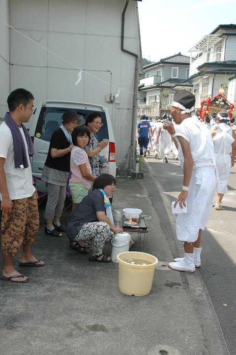 沿道では地元の人たちが手を合わせて神輿を迎えます=2014年8月24日、大槌町吉里吉里