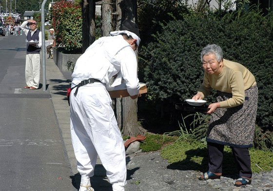 神輿を迎えた人たちは神輿がまく塩を用意し手渡しました＝2014年9月21日、大槌町