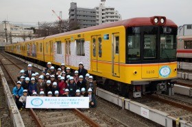 入賞者はラッピング電車を背に記念撮影。5月末まで運行される