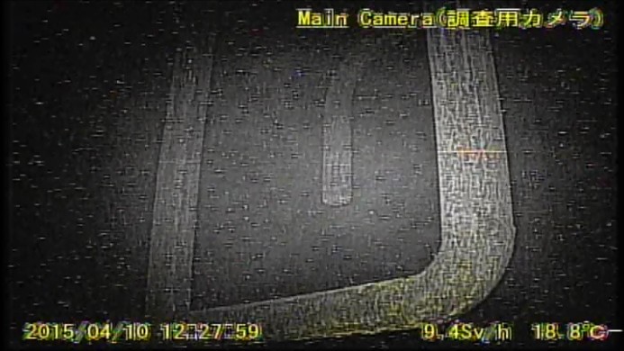 ロボットのカメラがとらえた格納容器内部の様子。右下に「毎時9.4シーベルト」の表示が確認できる（提供：国際廃炉研究開発機構）