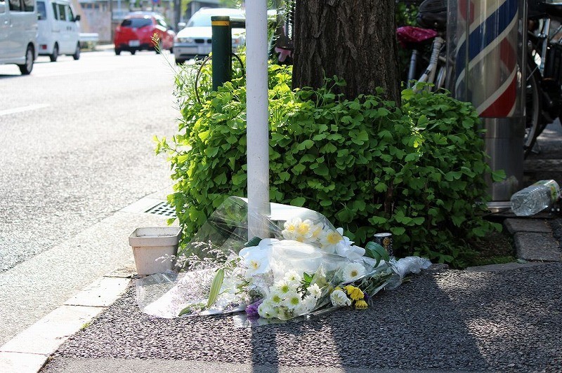 事故現場には花束が供えられている