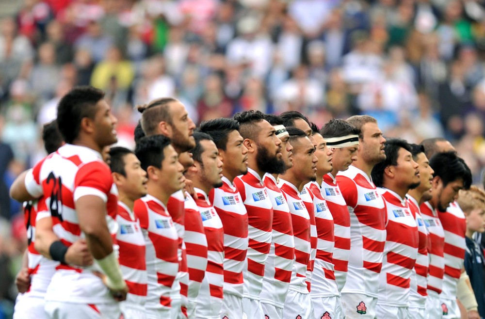 肩を組み「君が代」を斉唱する日本代表選手（写真：アフロ）