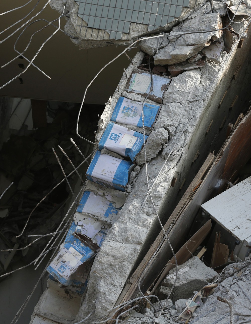 倒壊した建物の柱から見つかった一斗缶が波紋を広げている（写真：AP/アフロ）