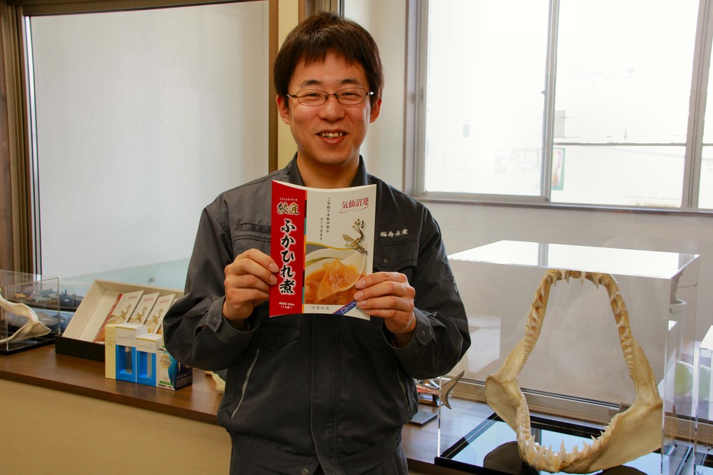 自社製品を手にする福寿水産専務・臼井祐介さん