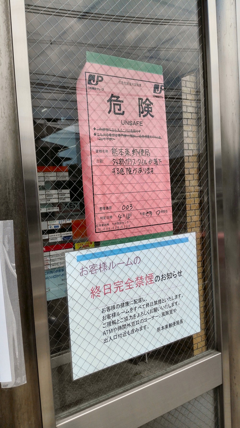 熊本市内の郵便局には、ドアに赤い「危険」の張り紙が