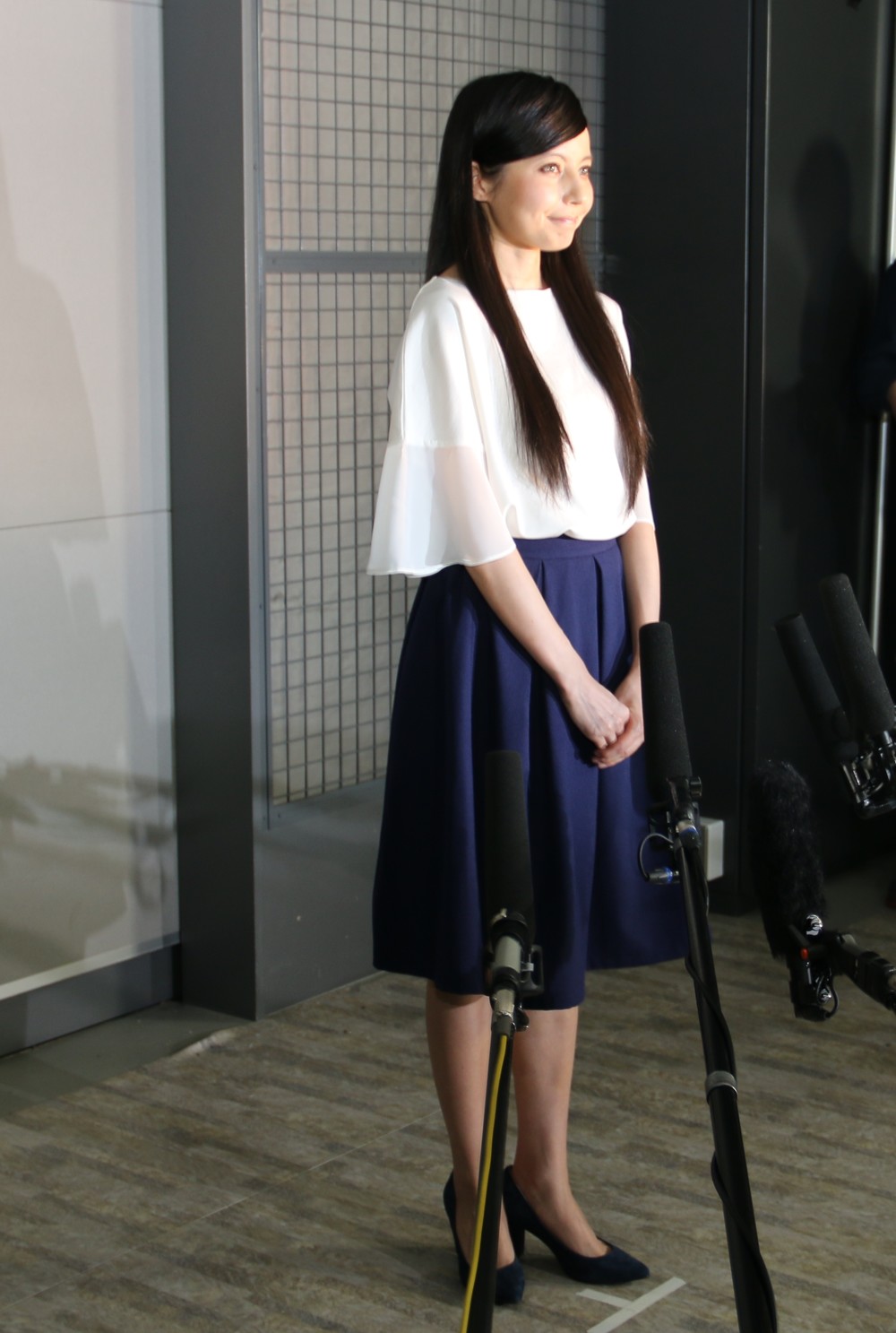 白のブラウスに紺のスカートで登場