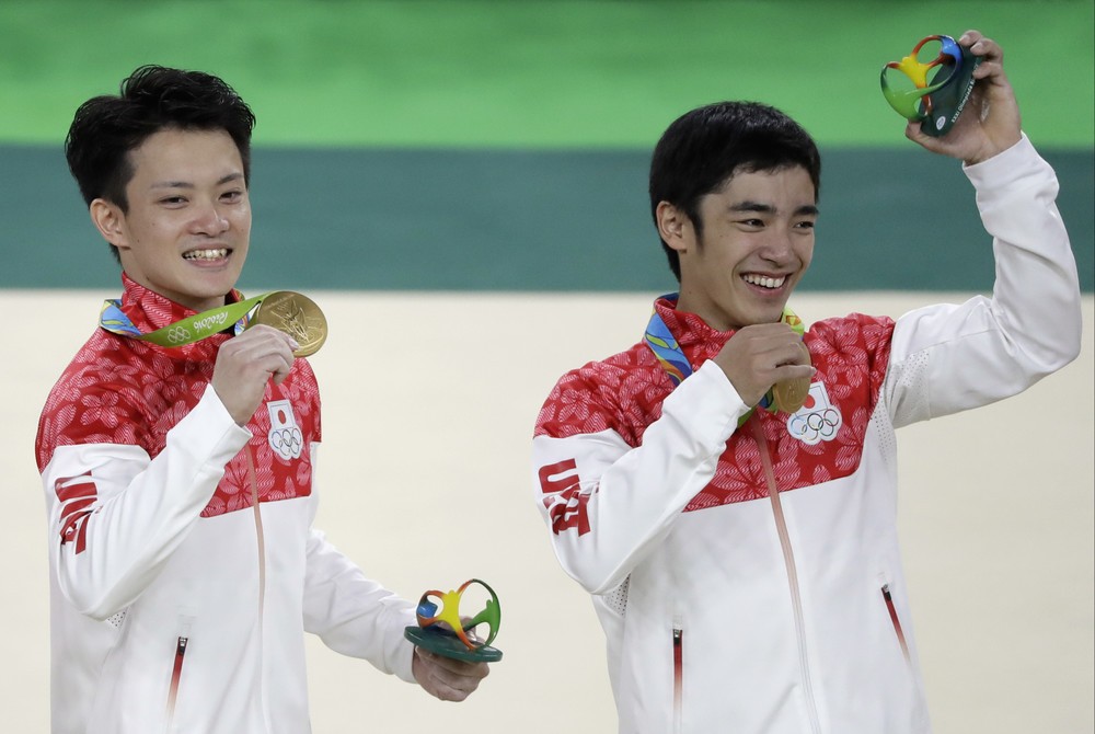  記念品を手にする白井健三選手（右）と田中佑典選手（左）（写真：AP/アフロ）