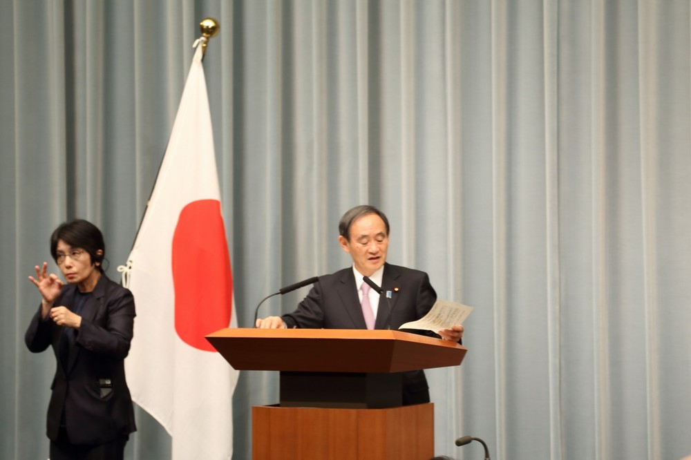 メモに目を落としながら質問に答える菅義偉官房長官
