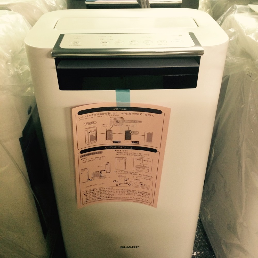 シャープの空気清浄機には、本体にピンク色の注意チラシが貼られている（提供：シャープ）