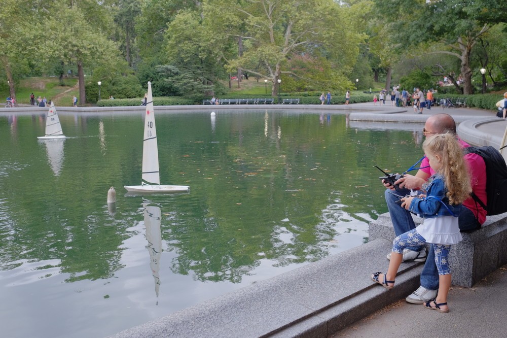 ニューヨークのセントラルパークの池で遊ぶ親子 