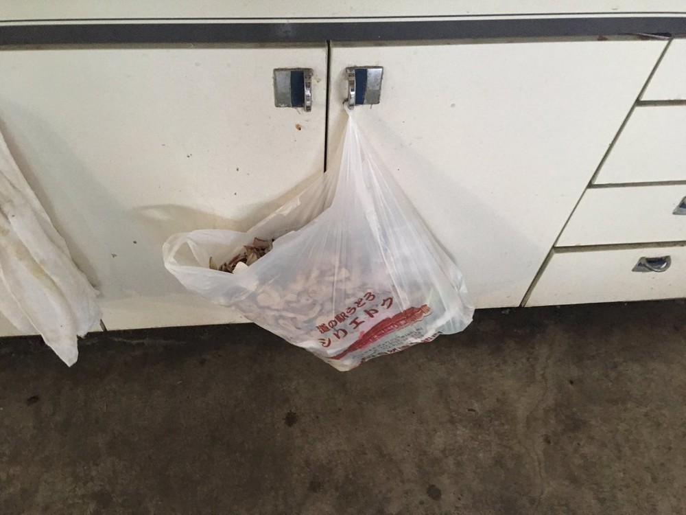 扉にかかったビニール袋には、大量の生ゴミが詰まっている。画像はまるこ（＠badminton523）さん提供