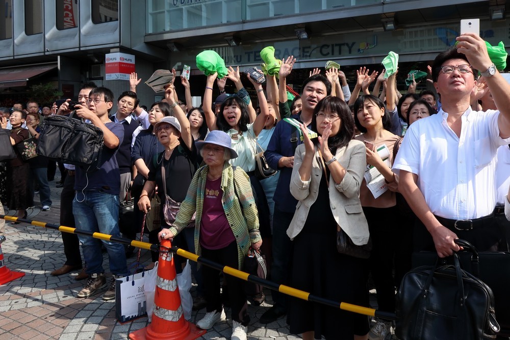 支持者は緑の帽子を持って集まった
