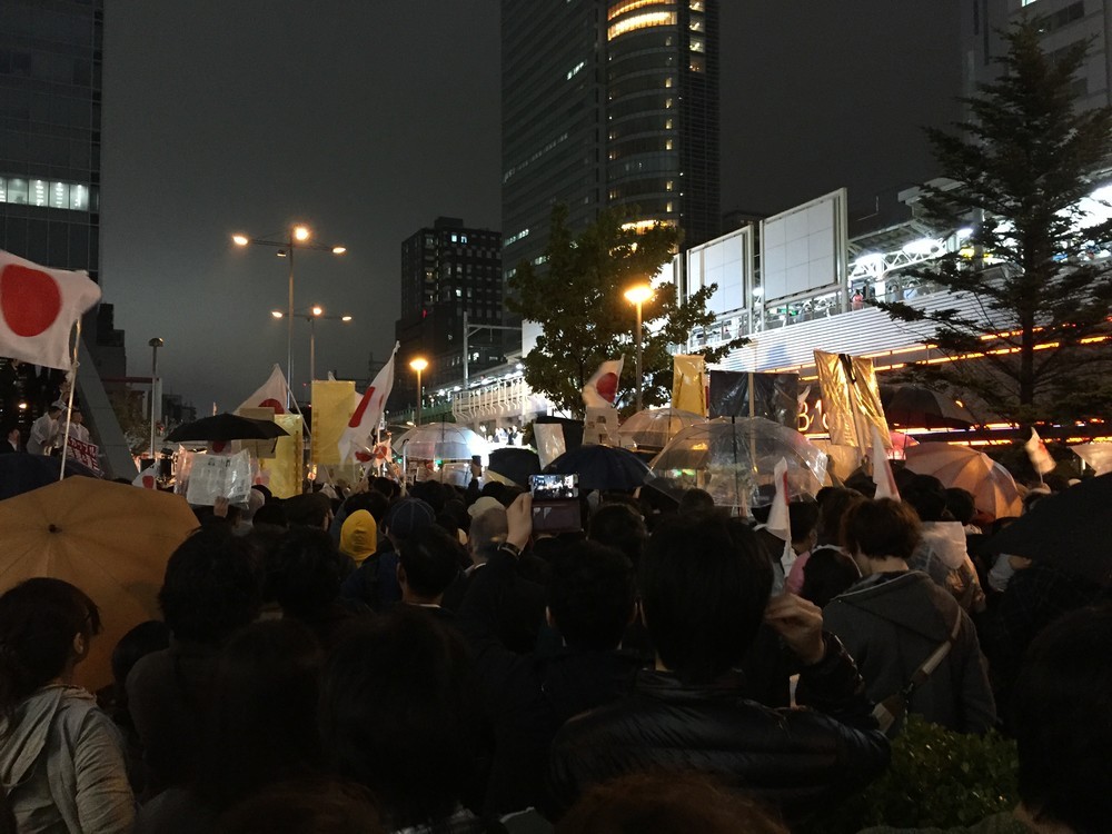 10月21日夜のJR秋葉原駅前。写真中央で白く光る選挙カーの上に、安倍氏らが立っている