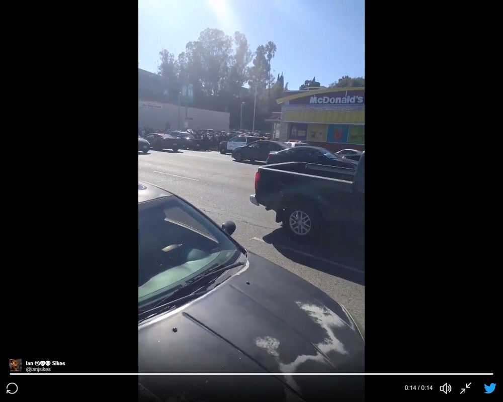 ＠ianjsikesさんがツイッターに投稿した動画。「四川風ソース」を求める群衆や警察の車がうつっている。
