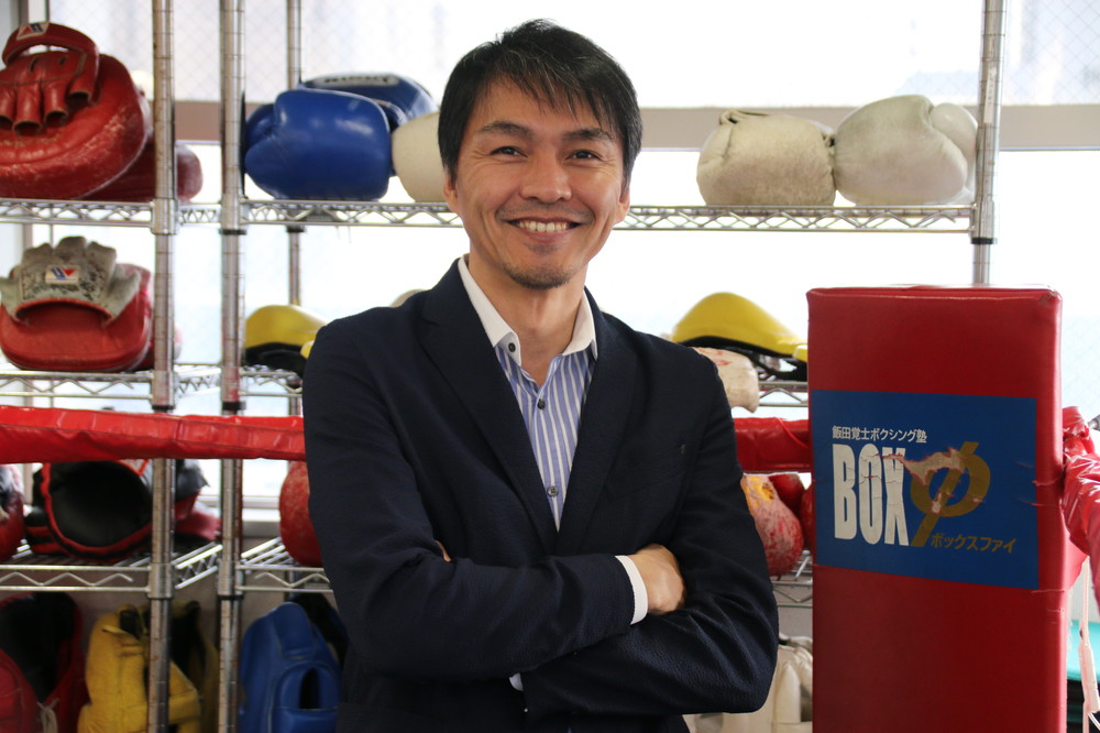 ジムにある「リング」で微笑む飯田さん
