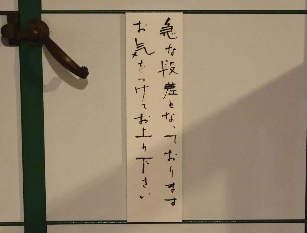 階段前に貼られた「急な段差となっております　お気をつけてお上り下さい」（特別に台東区立書道博物館の許可を頂いて撮影しています）