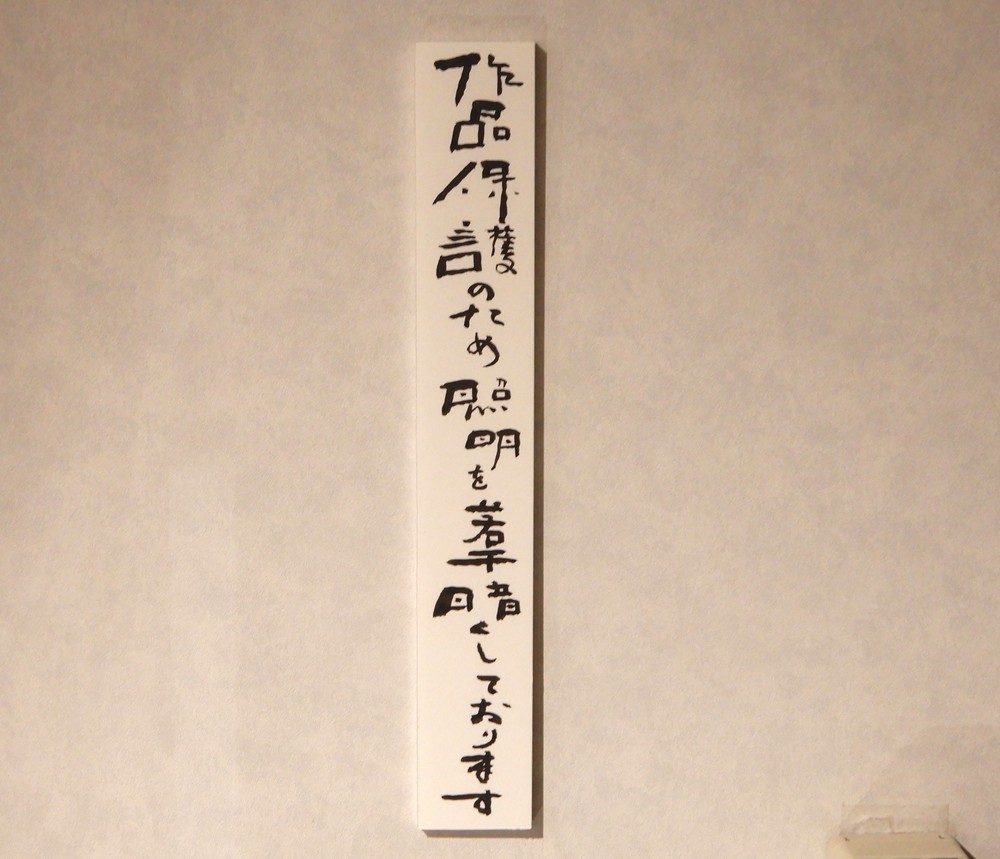 館内の貼り紙「作品保護のため照明を若干暗くしております」（特別に台東区立書道博物館の許可を頂いて撮影しています）
