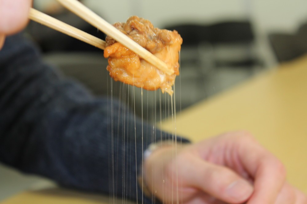 からあげを持ち上げると、納豆の糸が…