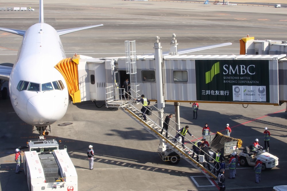 定刻から15分ほど過ぎた0時15分頃の様子。トランクケースをバケツリレーのようにして機内に運び込んでいる