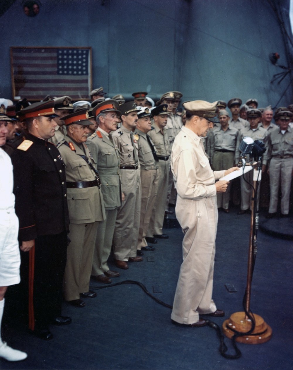 ミズーリ号上で行われた無条件降伏文書調印式でスピーチする連合軍最高司令官のダグラス・マッカーサー元帥。背後には「黒船来航」時の星条旗が飾られている
