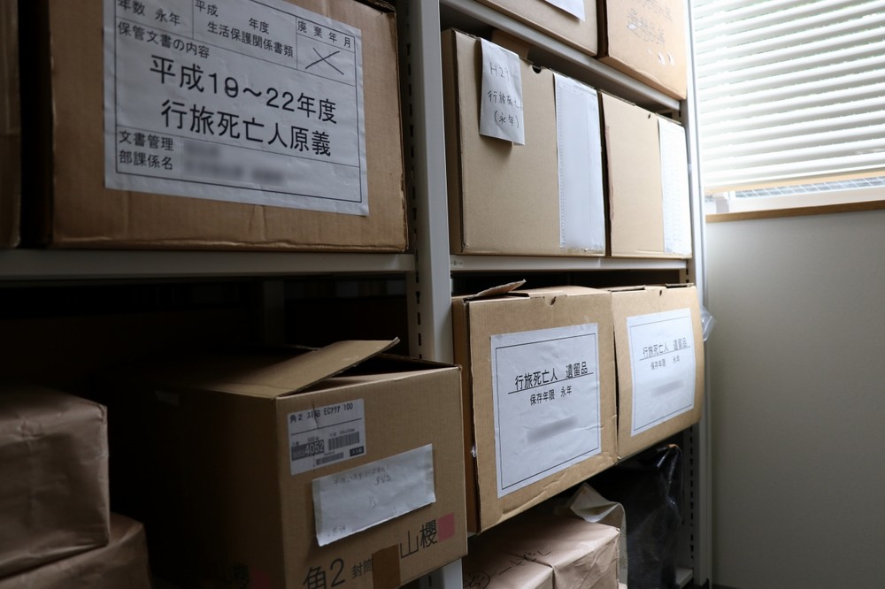 ある自治体で保管されている「行旅死亡人」の遺留品。ちょっと前に整理されたが、それでも段ボール箱4つ分にもなる。保管期限については統一の基準がなく、頭を悩ます自治体も少なくない