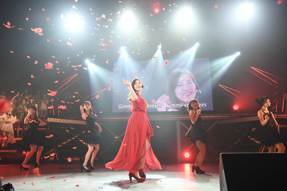 松井珠理奈さんが2018年9月16日、3か月ぶりにファンの前でパフォーマンスした楽曲は、ソロ曲「赤いピンヒールとプロフェッサー」（2015年）だった。黒いコートから赤いドレスへの「早替え」が印象的な曲だ　（c）AKS