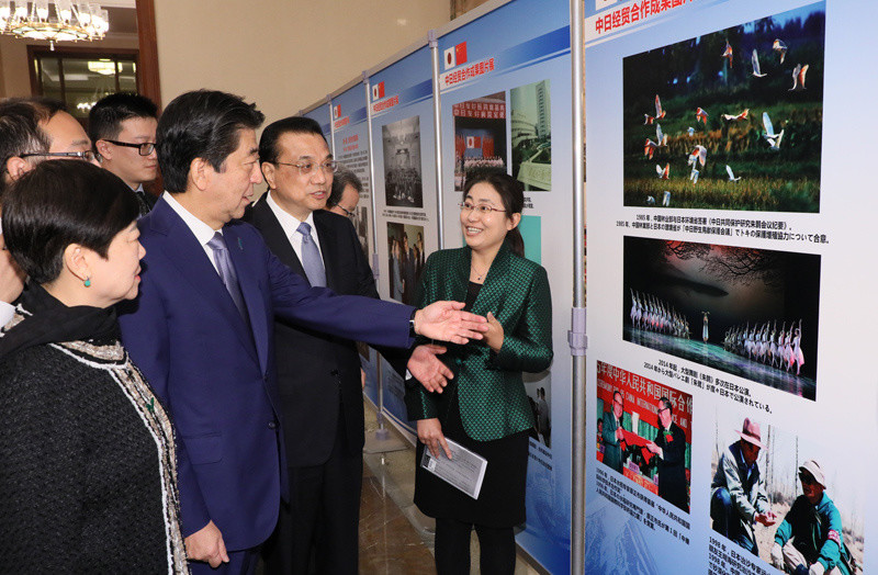 「日中経済協力写真展」を共に参観する安倍首相と李首相（内閣広報室提供）
