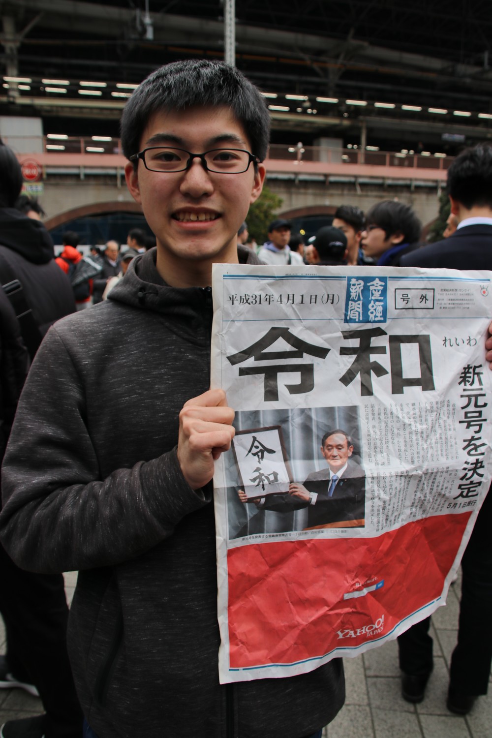 メガネを曲げながらも、号外を手にした北圭人さん