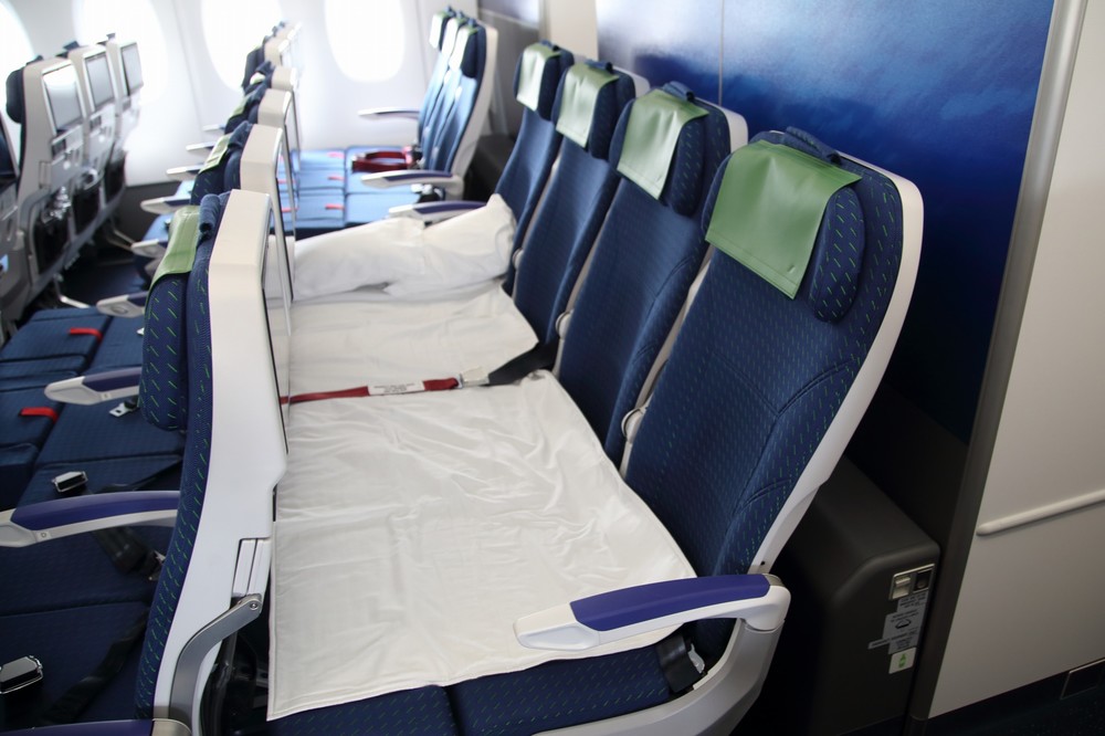 エコノミークラス後方に備えられたカウチシート。フットレストを水平に持ち上げて前の座席との間を埋めてベッド状にする
