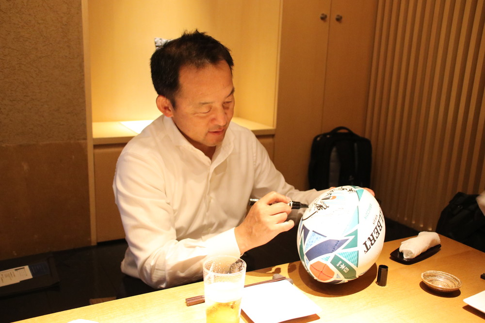 公式球にサインをする永友洋司さん