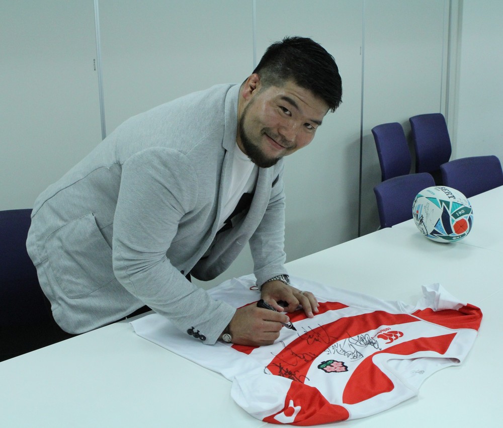 日本代表ジャージに笑顔でサインをする畠山選手