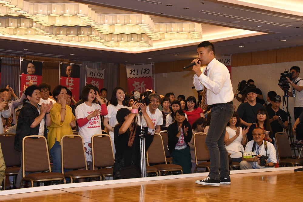 支持者らの前で述べる山本代表（右）