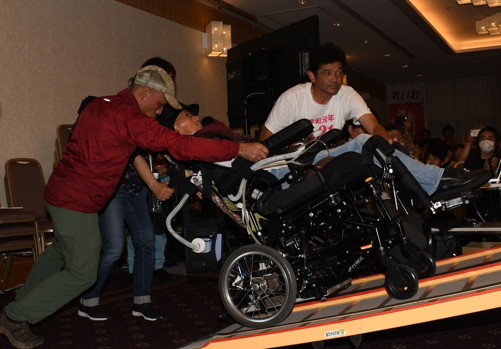 支援者らとともにスロープを降りる舩後氏