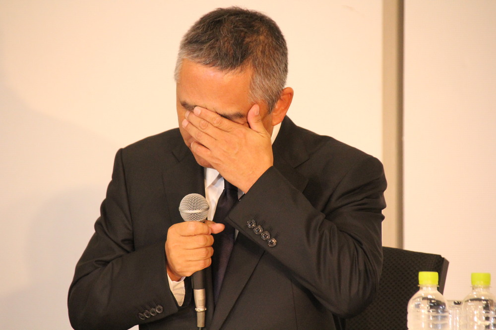 手で涙を拭う岡本社長