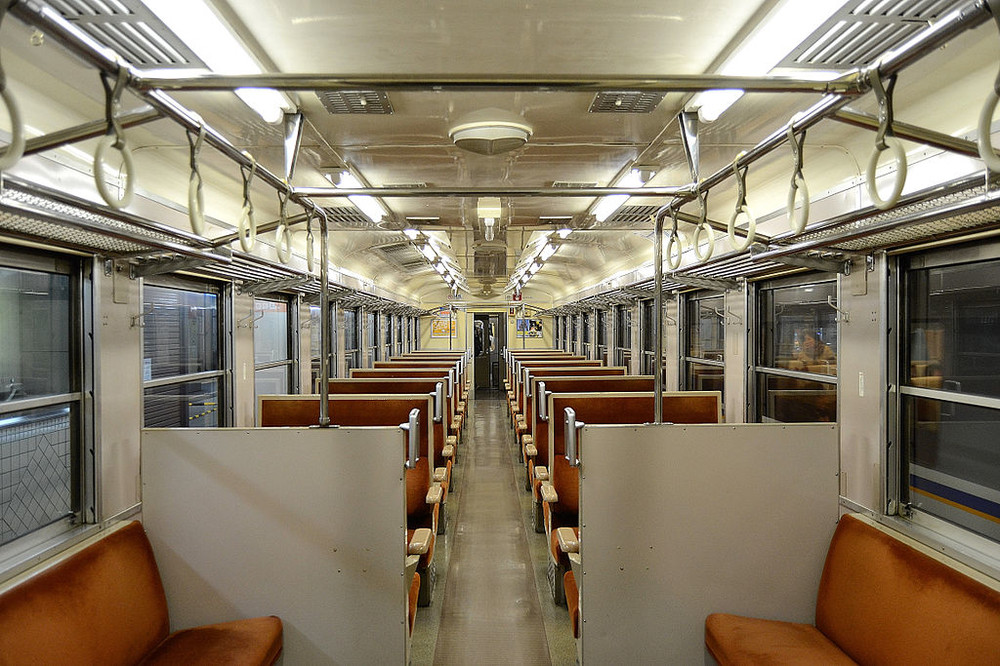 一部の座席が改造されたが、クロスシートに往年の急行型のスタイルが残っている車内（Wikimedia Commonsより）