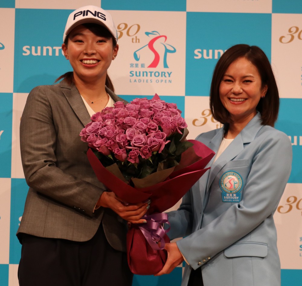サントリーとの所属契約を発表した渋野日向子選手（左）は「尊敬する」宮里藍さんからサプライズ花束を受け取り、笑顔を浮かべた