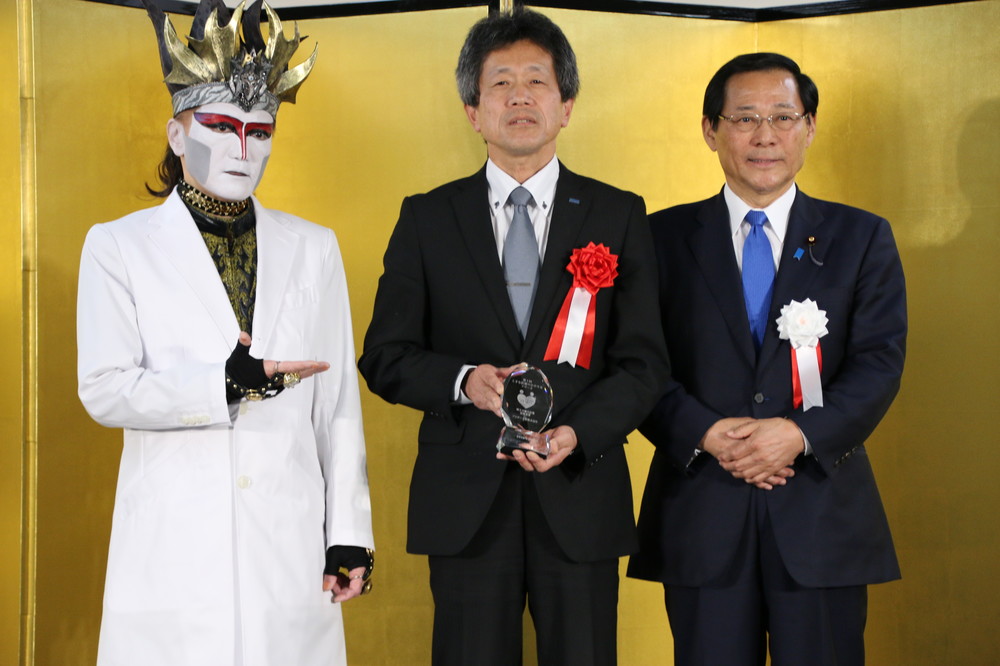 （左から）デーモン閣下、厚生労働大臣賞受賞のブラザー工業、小島政務官