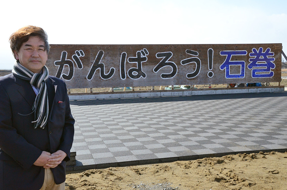 黒澤健一さん。「がんばろう！石巻」の看板前で