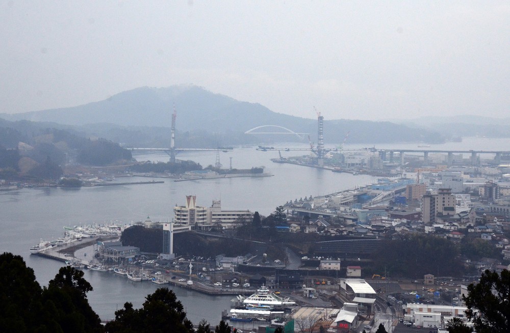 震災から9年の気仙沼中心部。写真中央に、現在工事が進む三陸沿岸道路「気仙沼湾横断橋」と、その後ろに昨年開通した気仙沼大島大橋が見える