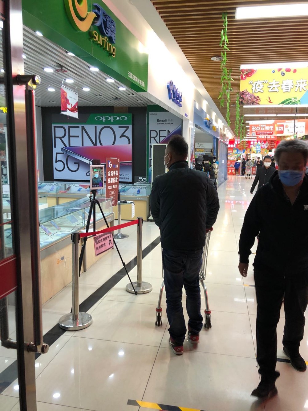 北京市内のスーパーには客が戻っている。ただ、すべての客は体温を測ってから中に入り、
店では足元の黄色い線で他の客と1メートルの距離を保とうとも呼びかけている（3月26日撮影）
