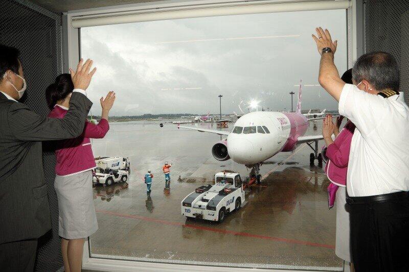 ピーチの森健明（もり・たけあき）代表取締役CEO（写真左）らが、この日運航を再開した便を見送った。15時過ぎに乗客63人を乗せて鹿児島に向けて出発した