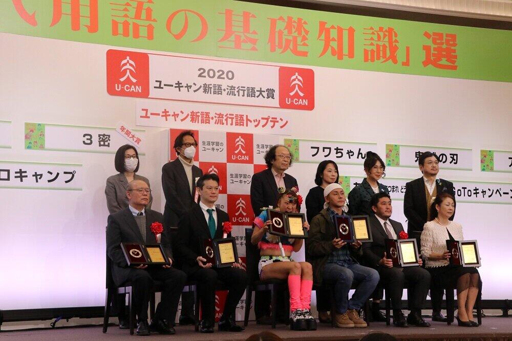 2020年の流行語大賞の受賞者（前列）と選考委員（後列）による記念撮影の中、かじりつく素振りを見せるフワちゃん（前列中央）