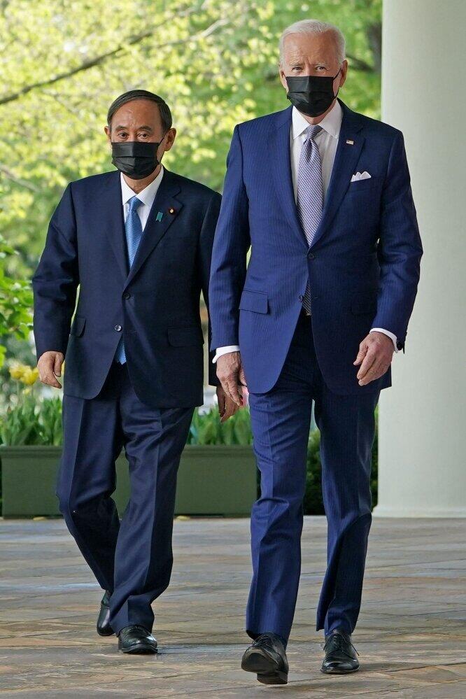 バイデン大統領とスーツ姿でホワイトハウスを歩く菅首相（写真：AFP/アフロ）