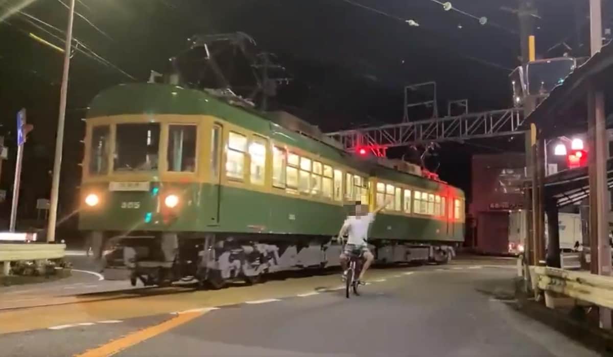 江ノ電と並走しながら左手を上げる自転車の男性（「ネイマール東日本」さん（＠Gifu_Hashima）投稿の動画から）
