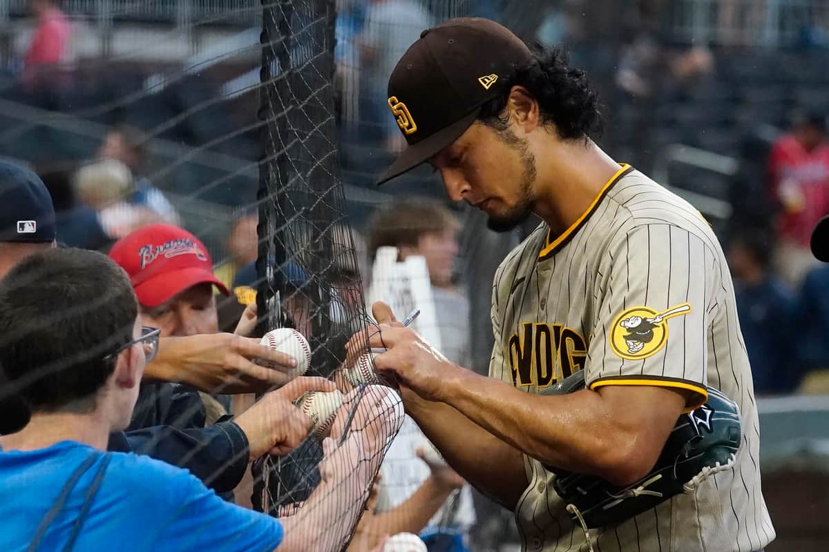 雨の中でサインを続けるダルビッシュ有投手（アトランタの試合で、写真：AP/アフロ）