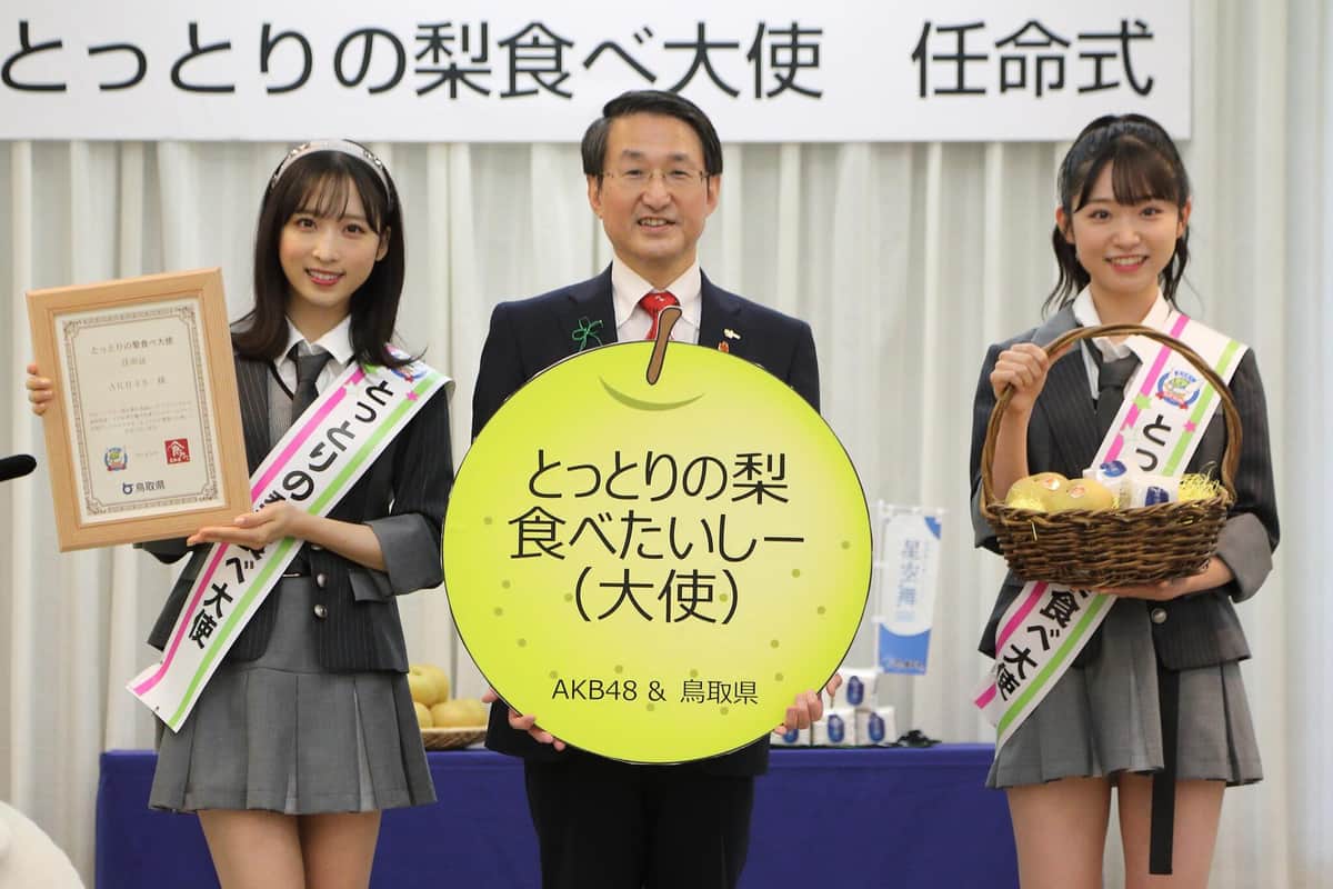 新曲が縁でAKB48が「とっとりの梨食べ大使」に任命され、任命式が開かれた。左からAKB48の小栗有以さん、鳥取県の平井伸治知事、AKB48の山内瑞葵さん