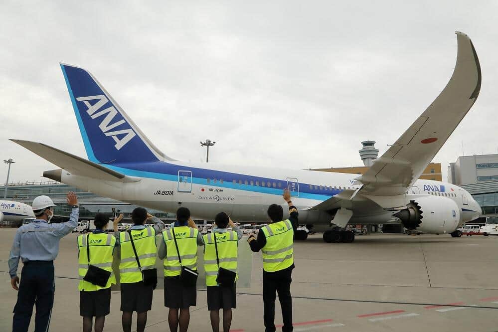 ボーイング787型機の就航10周年を記念するフライトは、空港係員の横断幕に見送られて岡山空港に向けて出発した