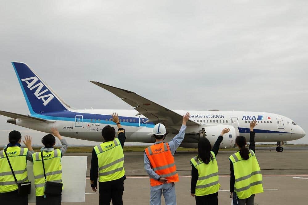 空港係員に見送られて出発するボーイング787型機